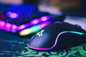 A close-up of a colorful gaming mouse and illuminated RGB keyboard, perfect for tech setups.